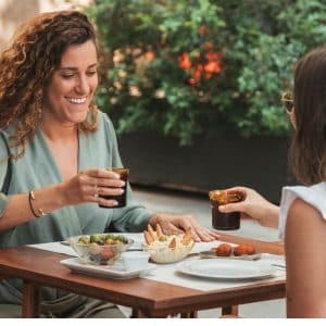 Persones gaudint d’un vermut i aperitius al Bar Nuri en un ambient acollidor i festiu